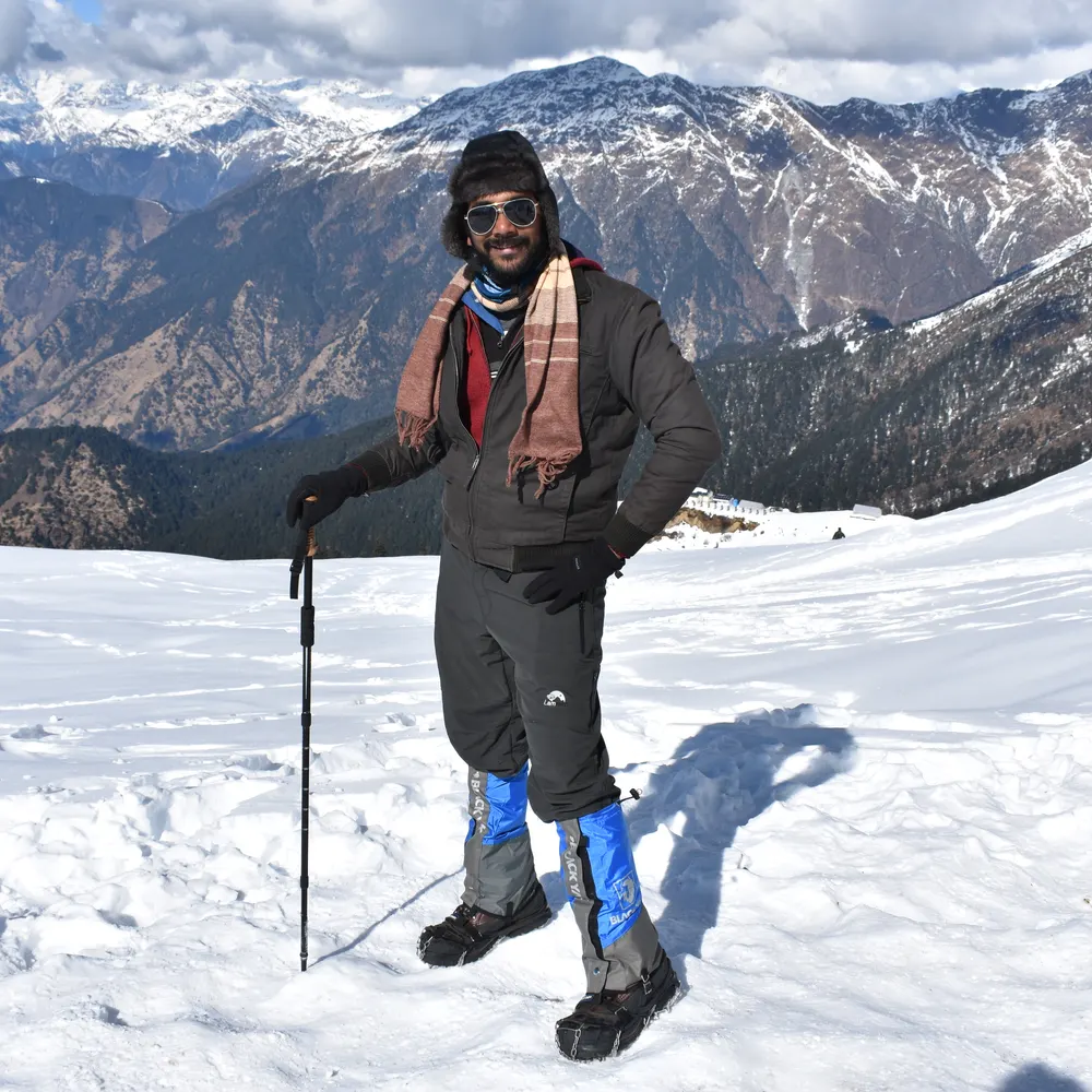 Banu in the snow at Chandrashila, with Himalayan peaks behind